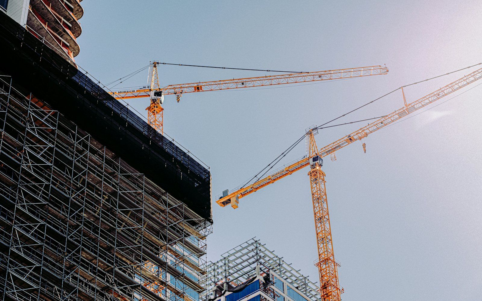 A construction site with cranes and a building under construction