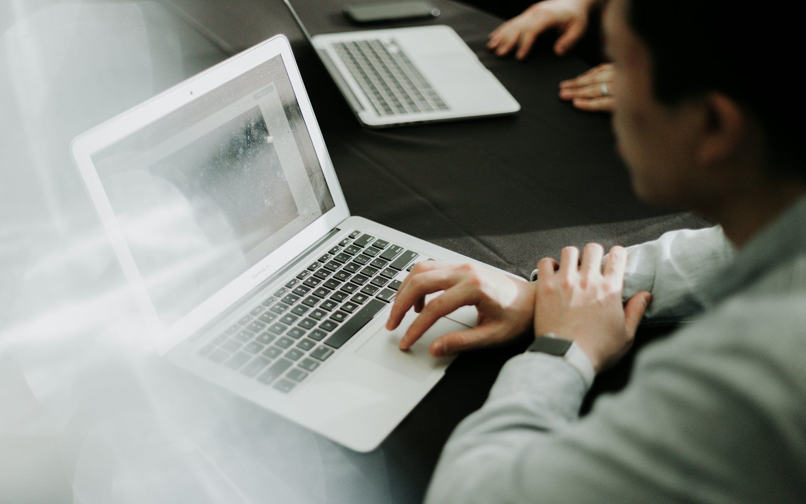 A desk adjuster reviewing a claim file and documents on a laptop