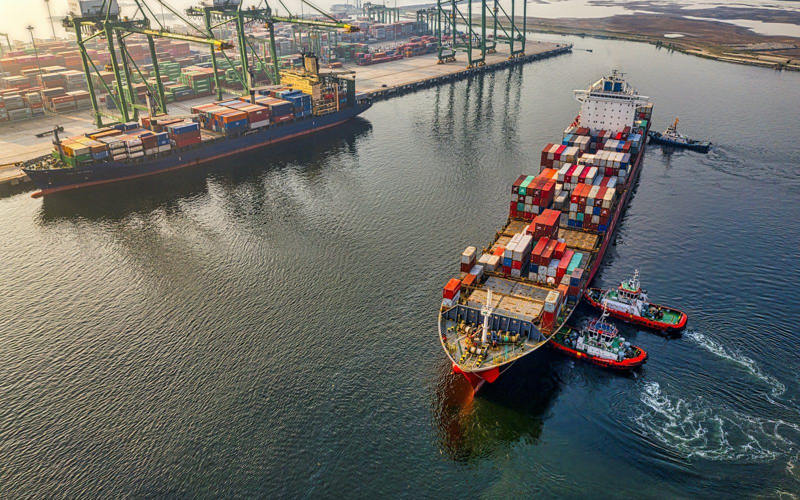 A cargo ship stacked with shipping containers at a port