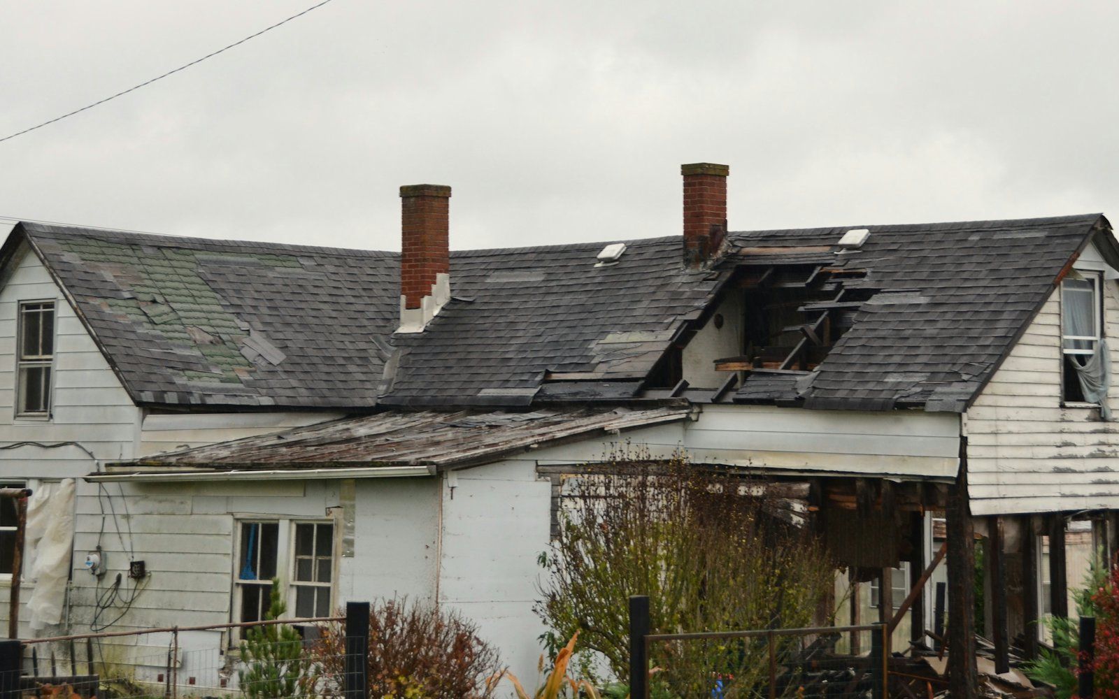 A storm-damaged house with a broken roof
